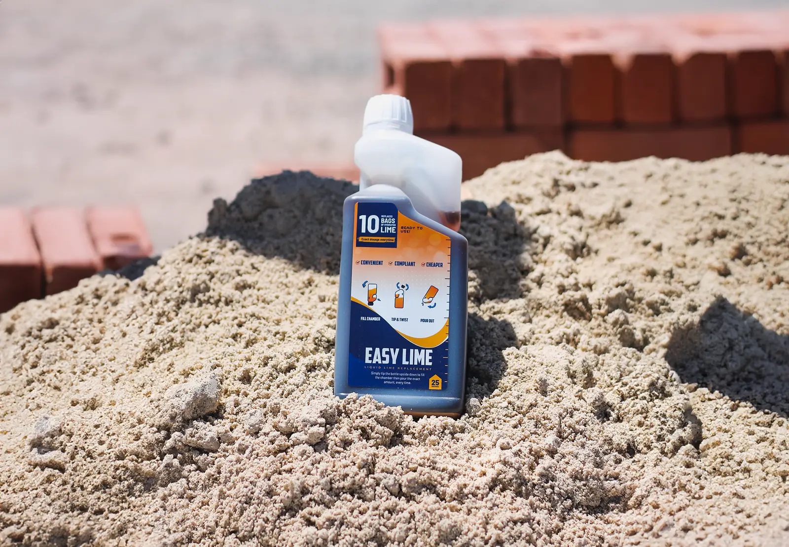 EasyLime liquid lime replacement bottle standing on mortar sand beside stacked clay bricks