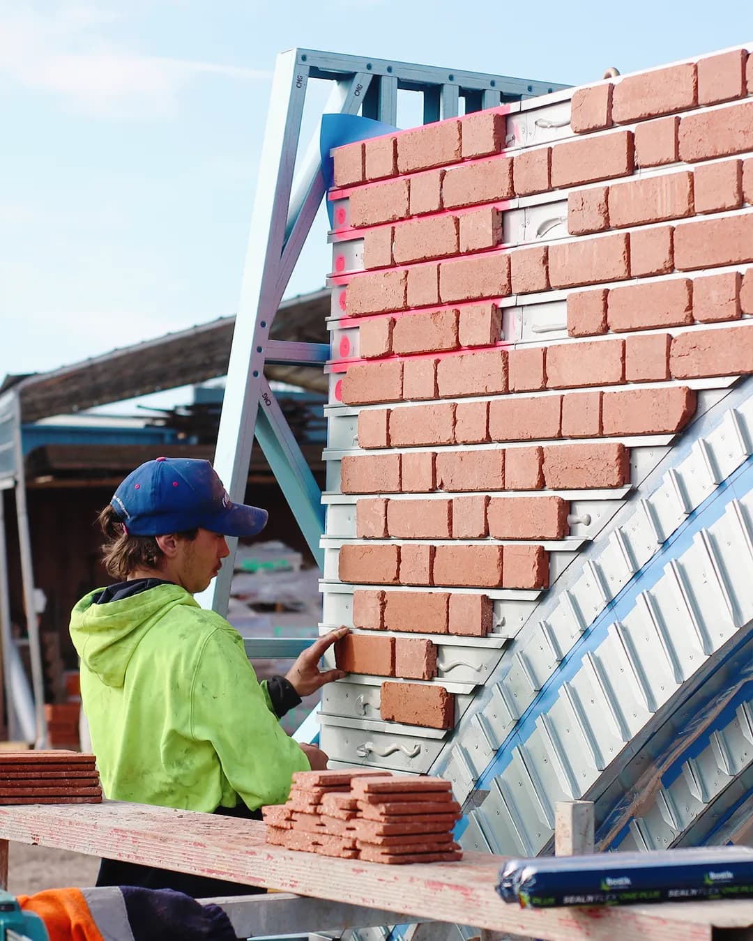 Installer fitting a real brick facing into a curved steel rail arch on site