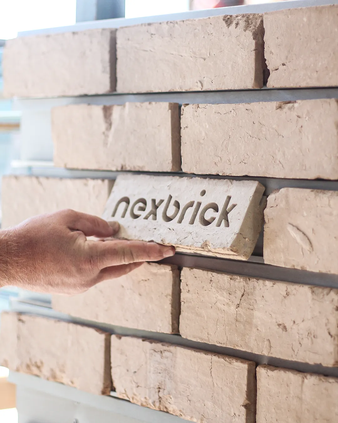 Nexbrick engraved clay brick facing held against an installed rail facade system